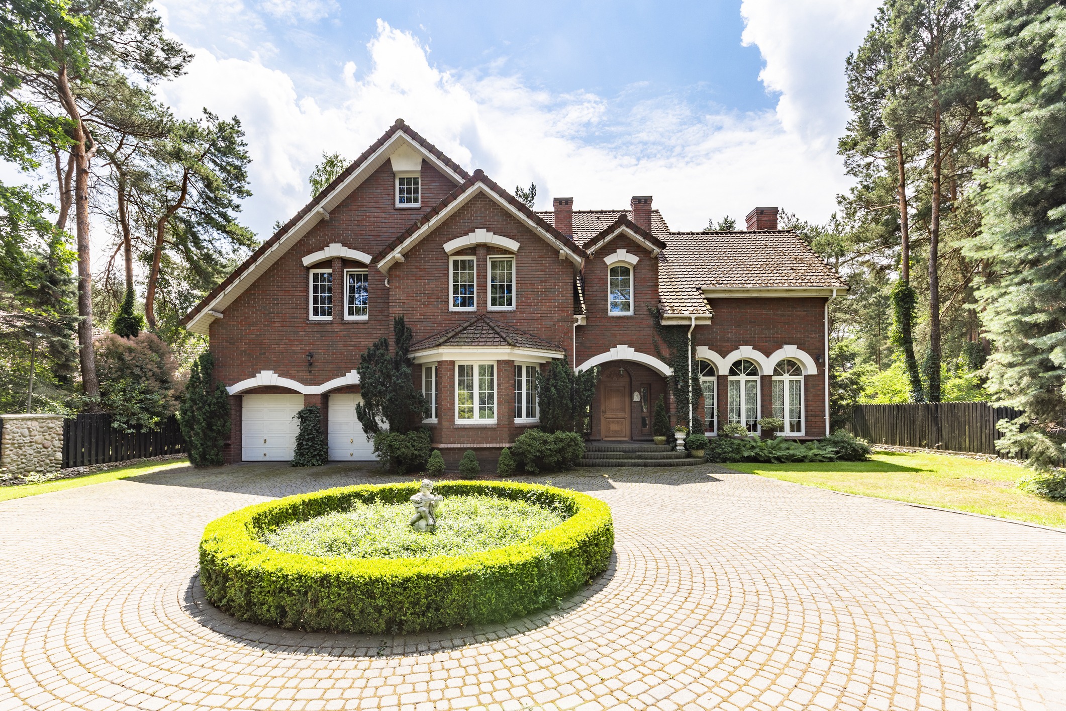 Round garden in the middle of driveway of english style residence during sunny day