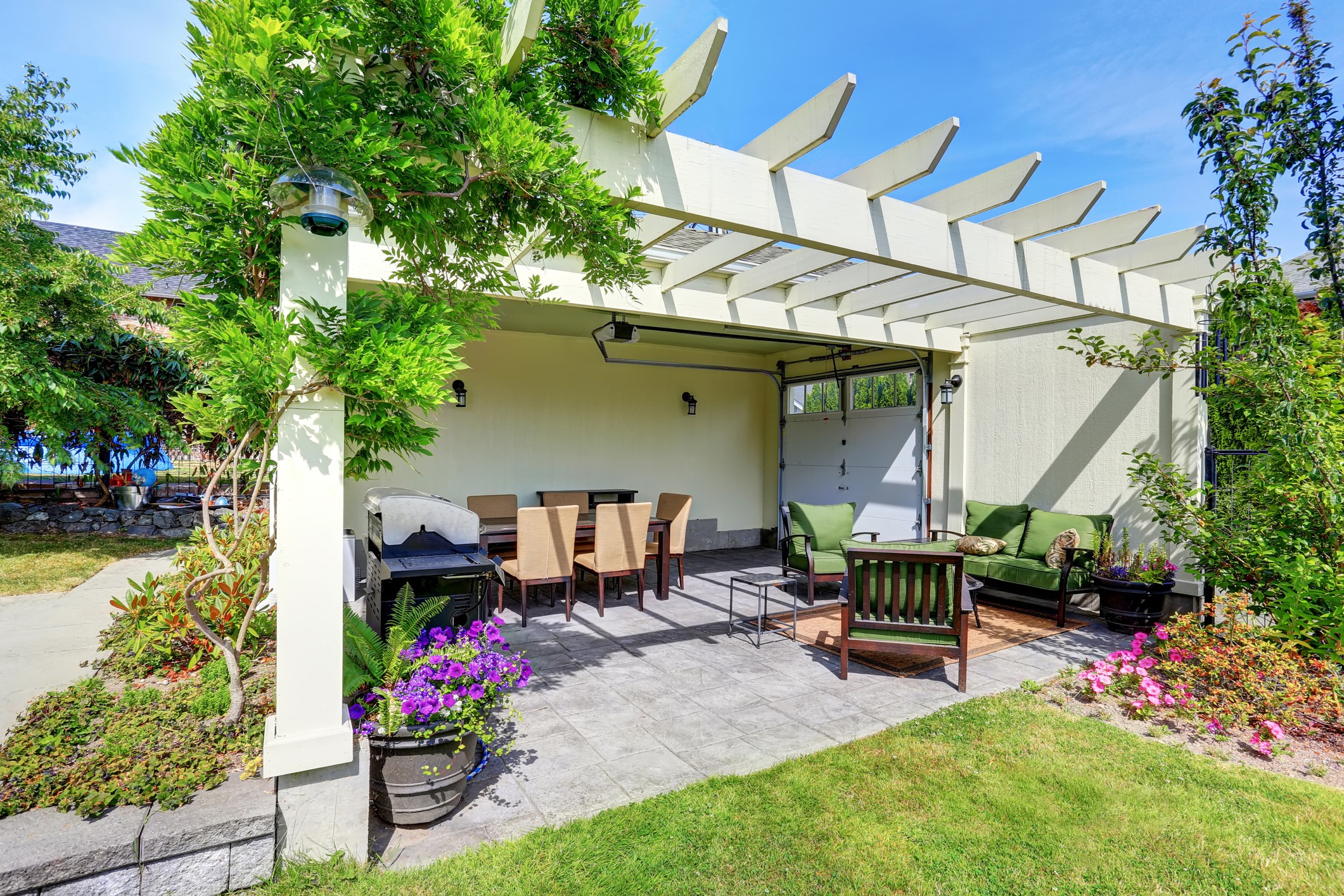 Covered patio area with outside chairs in the backyard garden. House exterior.