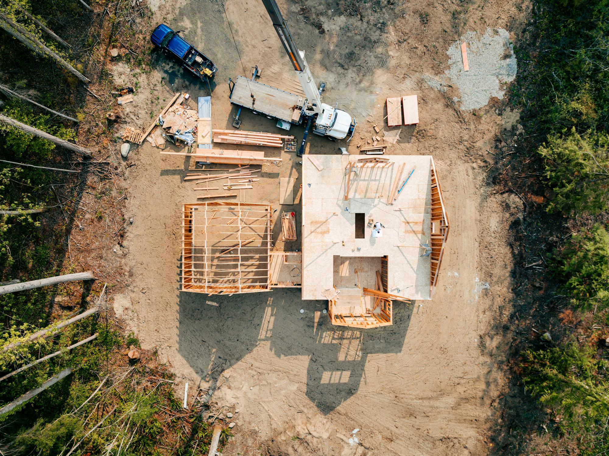 Aerial view of a home under construction surrounded by trees