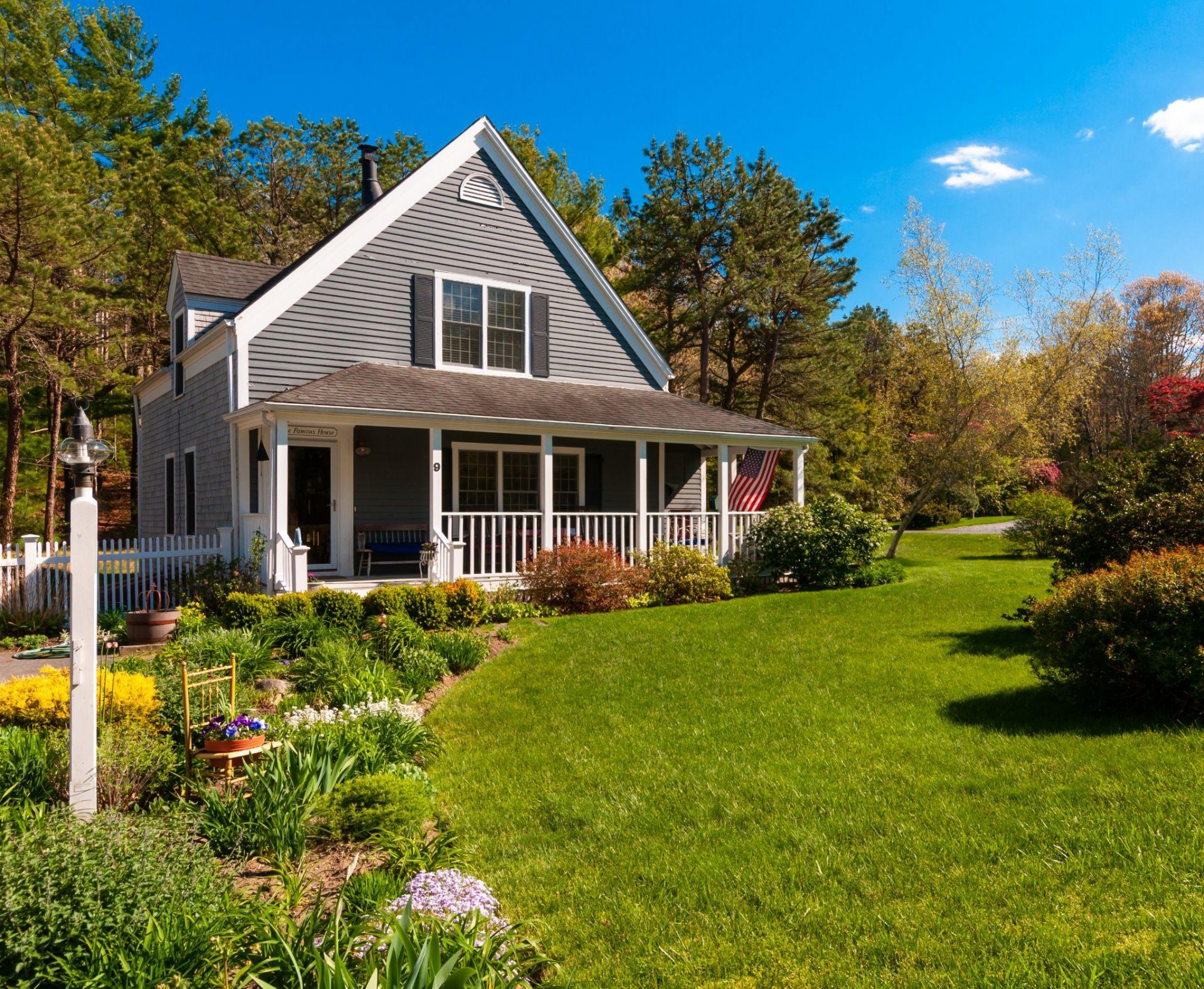 Cottage-style home with wraparound porch and colorful front garden