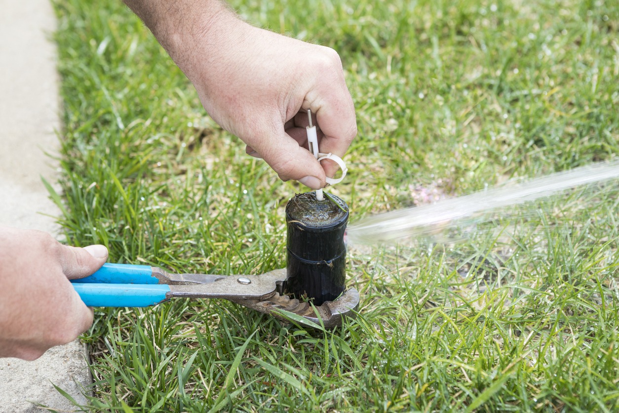 hand repairing a sprinkler
