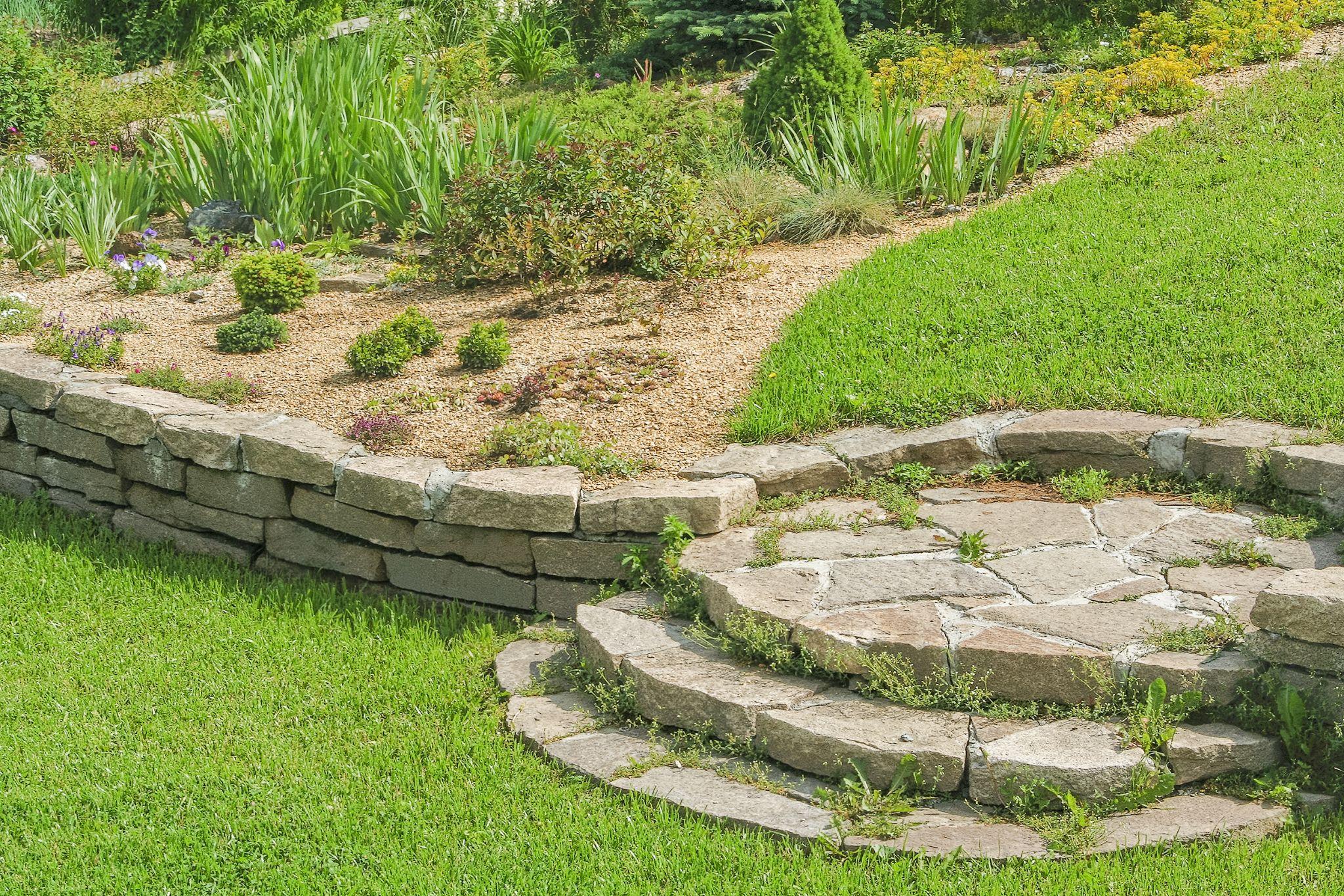 Natural stone retaining wall with flagstone steps and mixed garden planting
